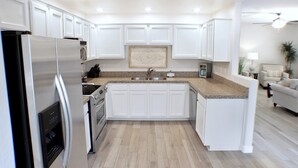A modern kitchen with white cabinets, stainless steel appliances, and a granite countertop. - 3BR condo near WestWorld (Scottsdale)