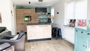 Una cocina moderna con armarios de madera, horno empotrado y una isla grande.