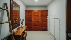 A bathroom with wooden cabinets, a mirror, a vanity, and a shower area. - Ancut Sari Private Villa (Ubud)