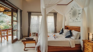A bedroom with a wooden bed, white bedding, a canopy, and a view of greenery outside. - Ancut Sari Private Villa (Ubud)