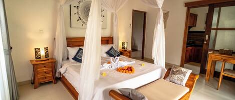 A four-poster bed with a canopy, wooden nightstands, a bedside table, and a wooden bench.