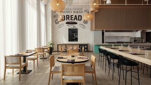 A modern restaurant with a brick wall mural, wooden furniture, and pendant lighting. - Four Points By Sheraton Dakar Diamniadio (Diamniadio)