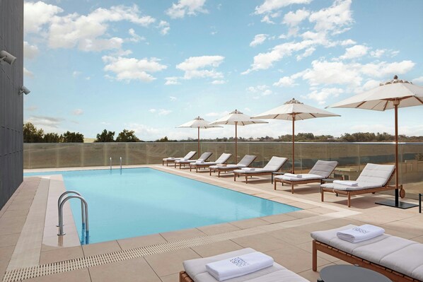 Piscine extérieure, parasols de plage, chaises longues