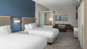 A hotel room with two beds, a sofa, a desk, and a large window. - Springhill Suites By Marriott Raleigh Garner (Garner)