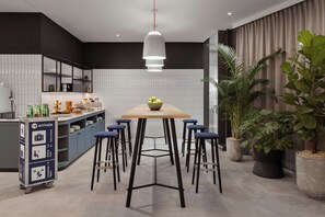 Une cuisine moderne avec un îlot central, des tabourets de bar et des plantes en pot.
