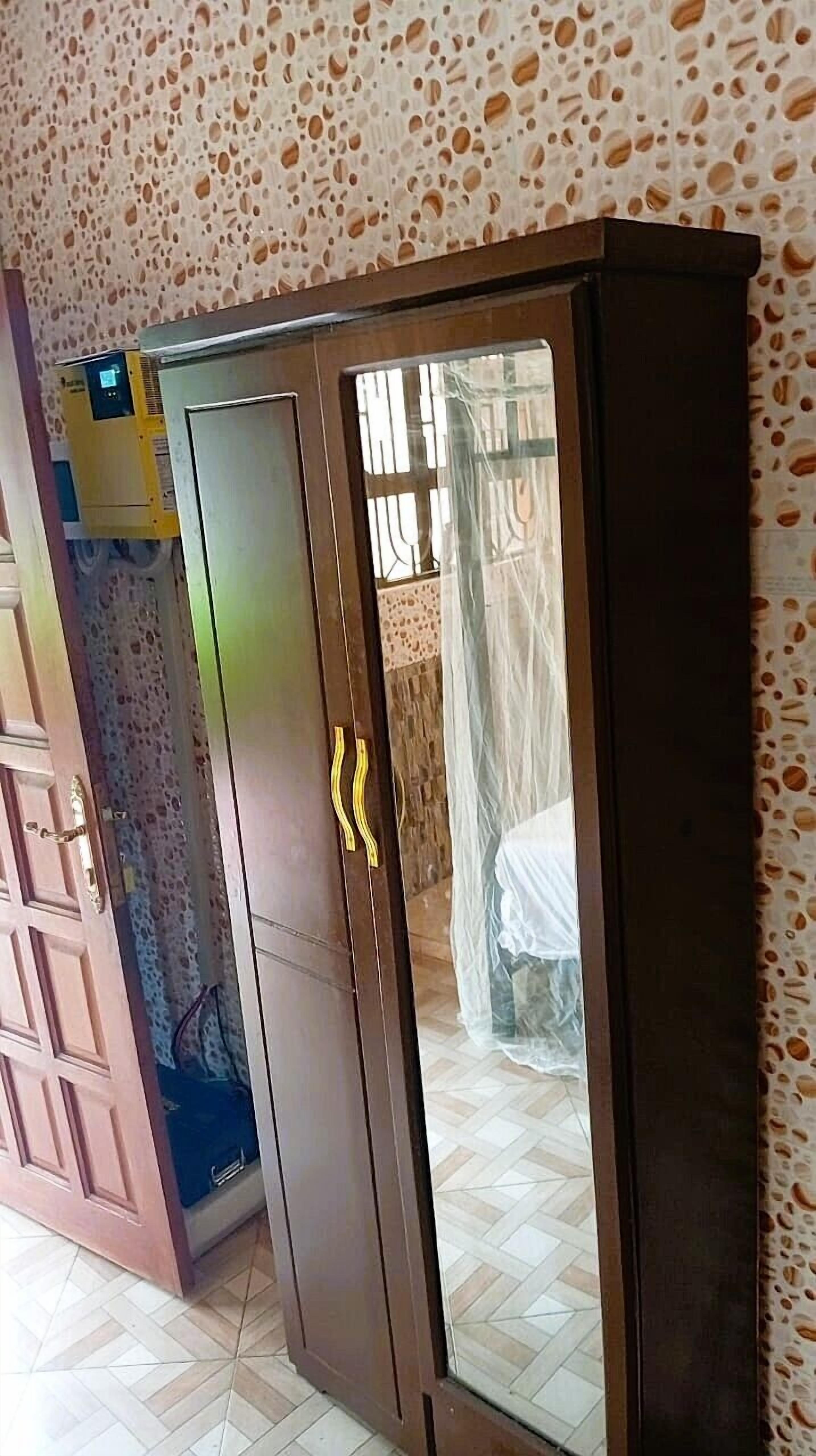 Ein Kleiderschrank mit Spiegel und kleinem Fenster.