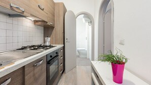 Eine moderne Küche mit Holzausstattung, einem Gasherd und einer Arbeitsplatte.