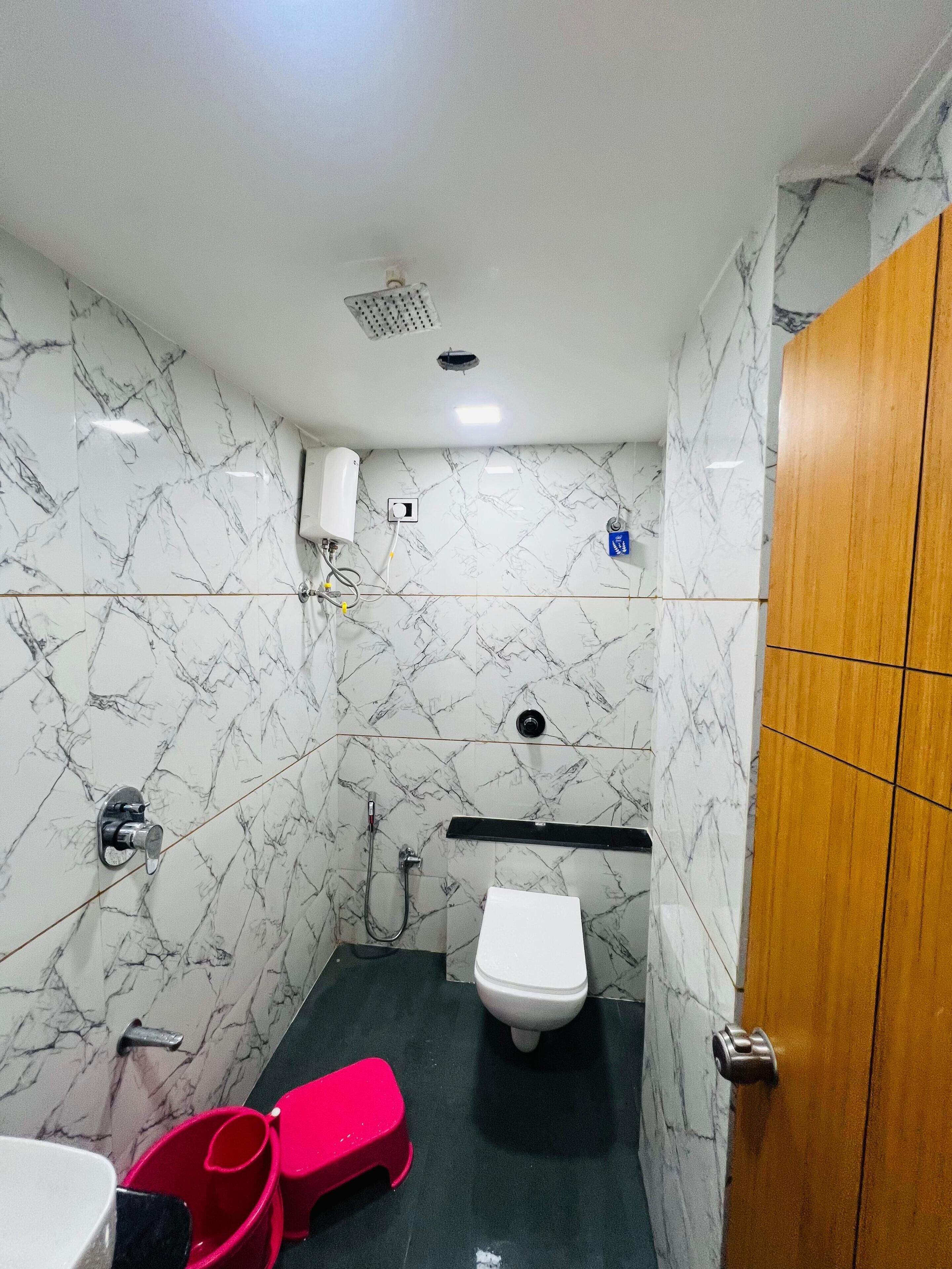 A small bathroom with a toilet, a shower, and a sink.