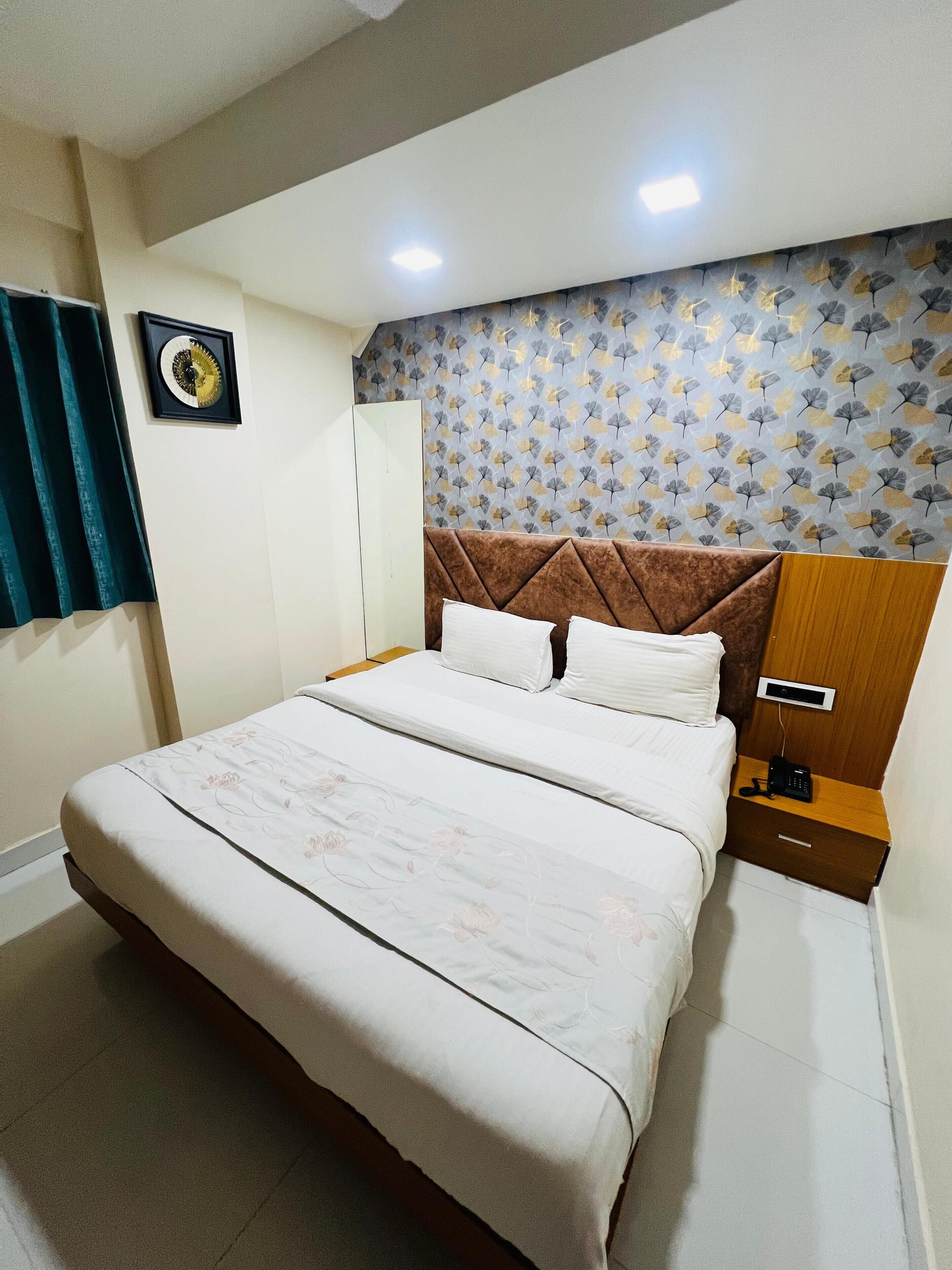 Un dormitorio ordenado con cama, mesita de noche y un reloj de pared.