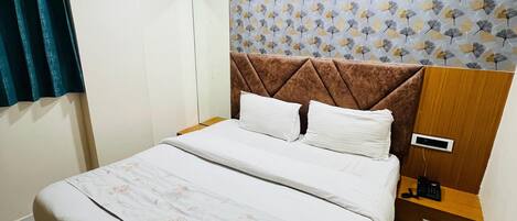 Un dormitorio ordenado con cama, mesita de noche y un reloj de pared.