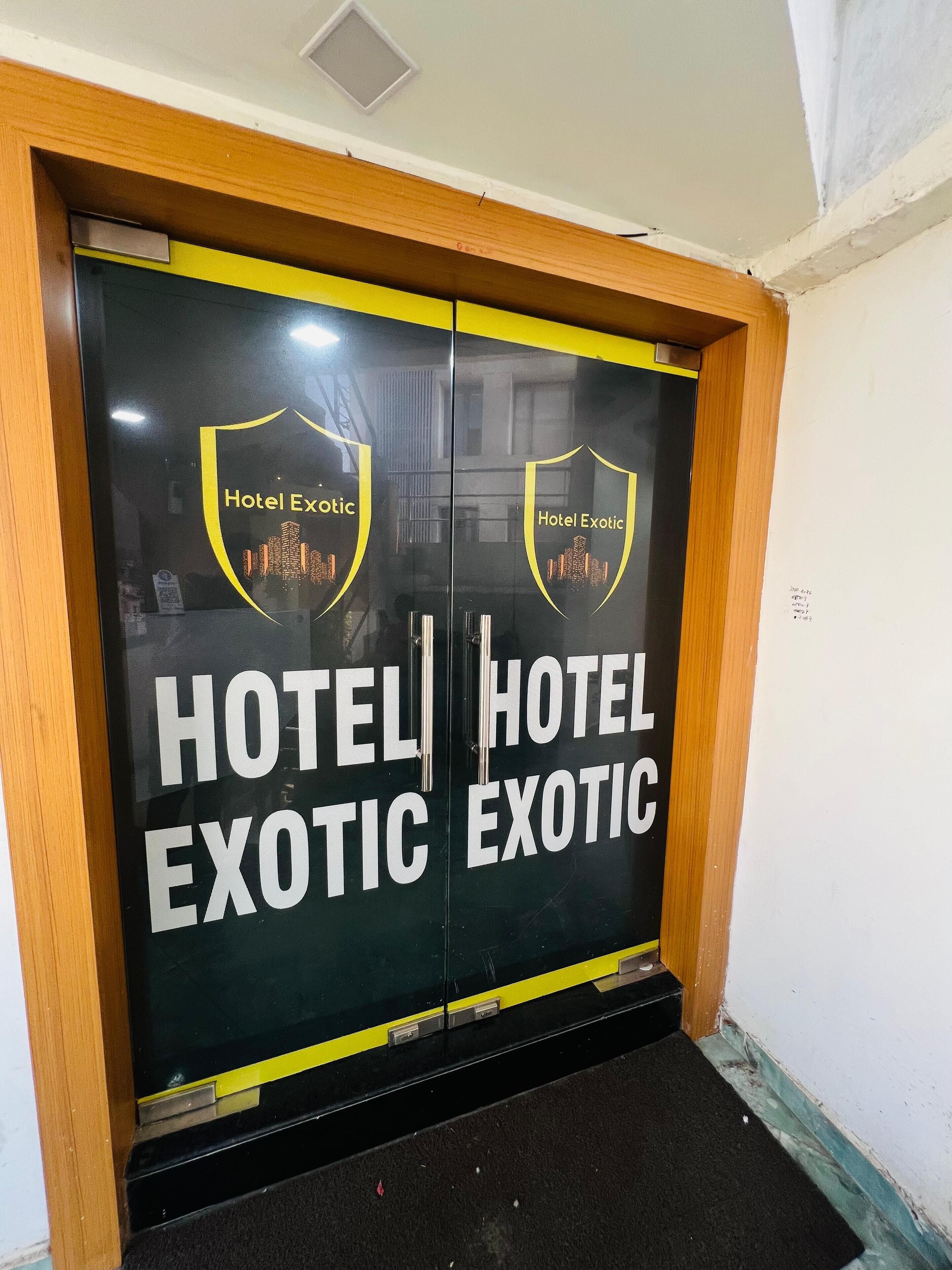 A double door entrance with the text "HOTEL EXOTIC" and a logo featuring a cityscape.
