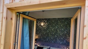 Une chambre confortable avec un lit, des oreillers et un papier peint à motifs floraux.