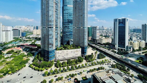 Un paisaje urbano con modernos rascacielos, una plaza central y una autopista.