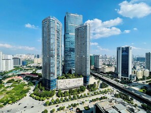A cityscape with modern high-rise buildings, a central plaza, and a highway. - Daniel Homes - Vinhomes SkyLake Luxury (Hanoi)