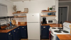 Una cocina equipada con refrigerador, estufa, microondas y armarios de madera.