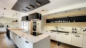 Una cocina moderna con una isla central, electrodomésticos integrados y una vinoteca.
