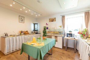 A breakfast area with a green table, kitchen appliances, and a window with curtains. - Styria Apartment near hiking trails (No Deposit) (Eisenerz)