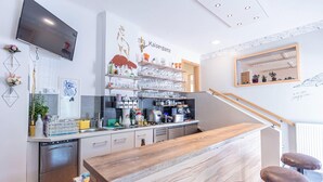 A modern kitchen with a wooden counter, stainless steel appliances, and a mounted TV. - Nice apartment in Stryia with sauna (No Deposit) (Eisenerz)