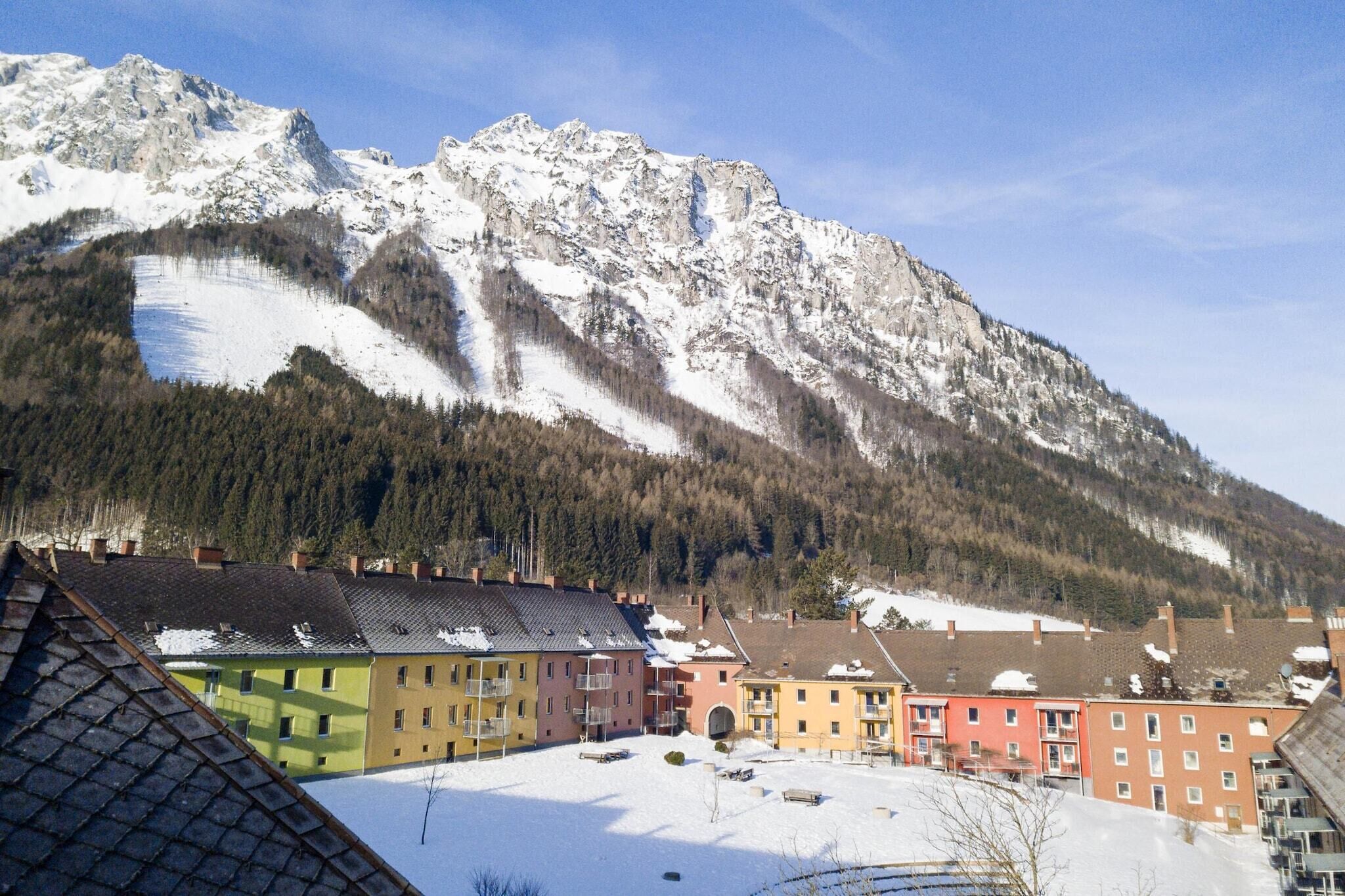 A snow-covered mountain with a residential area in the foreground.