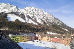 Ein schneebedeckter Berg mit einer Wohngegend im Vordergrund.