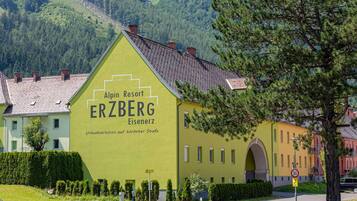 Ein Gebäude mit einem Schild, auf dem „Alpin Resort ERZBERG Eisenerz“ steht, und einem Geschwindigkeitsbegrenzungsschild mit 30.
