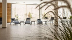 A spacious lobby with modern chairs, large windows, and potted plants. - Lush apartment with private sauna (Schladming - Rohrmoos)