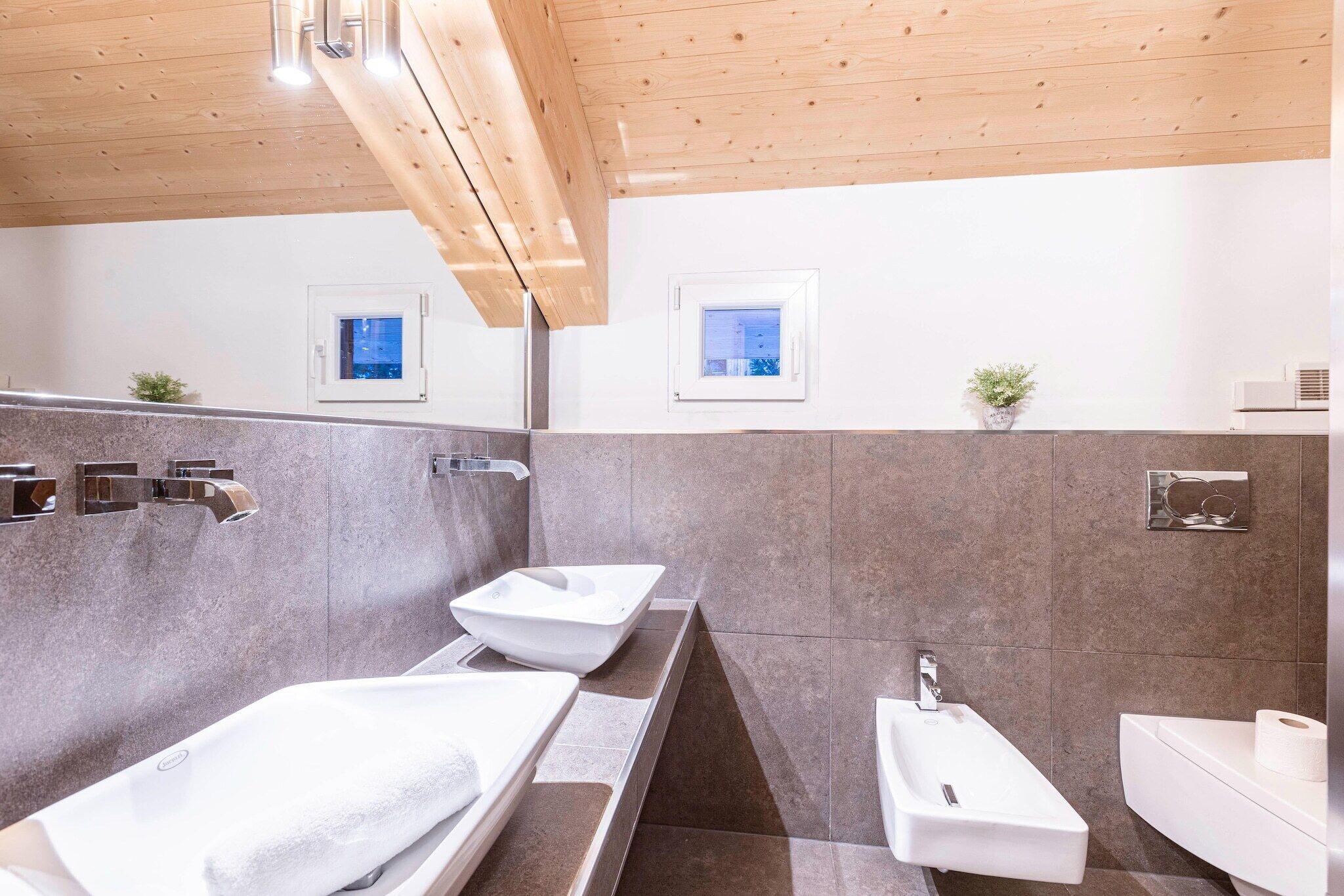 A modern bathroom with two sinks, a bathtub, and a shower.
