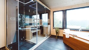 Une salle de bain moderne dotée d’une douche à parois de verre, d’un meuble-lavabo en bois et d’une grande fenêtre offrant une vue sur l’extérieur.