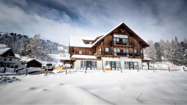 A large wooden lodge with multiple balconies and a sign reading "Residence N2".