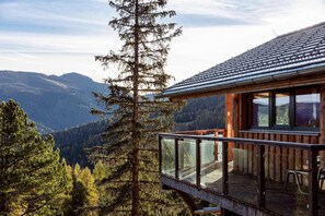 A wooden cabin with a glass balcony overlooking a mountainous landscape. - Amazing chalet with whirlpool (Turracherhöhe)
