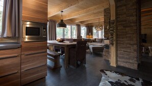 A modern kitchen with a built-in microwave, wooden cabinets, and a dining area with a bench and chairs.