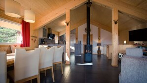 A spacious living area with a high ceiling, wooden beams, a fireplace, and a television. - Chalet near Ski Resort in Austria with Sauna (Turracherhöhe)