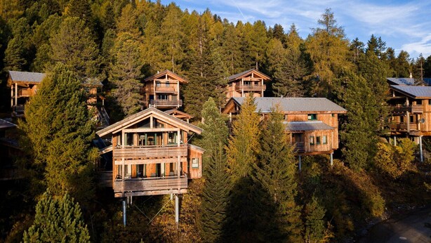 A cluster of wooden cabins on a hillside with a forest backdrop. - Chalet in Austria near Ski Resort (Turracherhöhe)