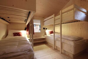 En træhytte med køjesenge, et vindue og et lille bord.