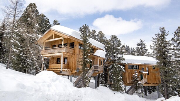 A wooden cabin with a balcony, surrounded by snow-covered trees. - Chalet in Alps near Ski Slopes & Sauna (Turracherhöhe)