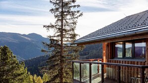 A wooden cabin with a glass balcony overlooking a mountainous landscape. - Chalet in Alps near Ski Slopes & Sauna (Turracherhöhe)