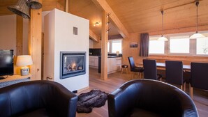 A cozy wooden interior with a fireplace, modern kitchen, dining area, and leather seating. - Chalet in Alps near Ski Slopes & Sauna (Turracherhöhe)