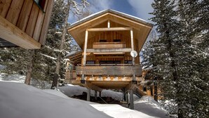 A wooden cabin with a balcony, surrounded by snow-covered trees. - Amazing chalet with infrared sauna (Turracherhöhe)