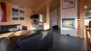 Una sala de estar acogedora con chimenea, una estantería y un televisor.