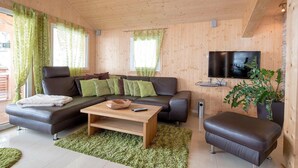 A modern living room with a sofa, a coffee table, and a TV.