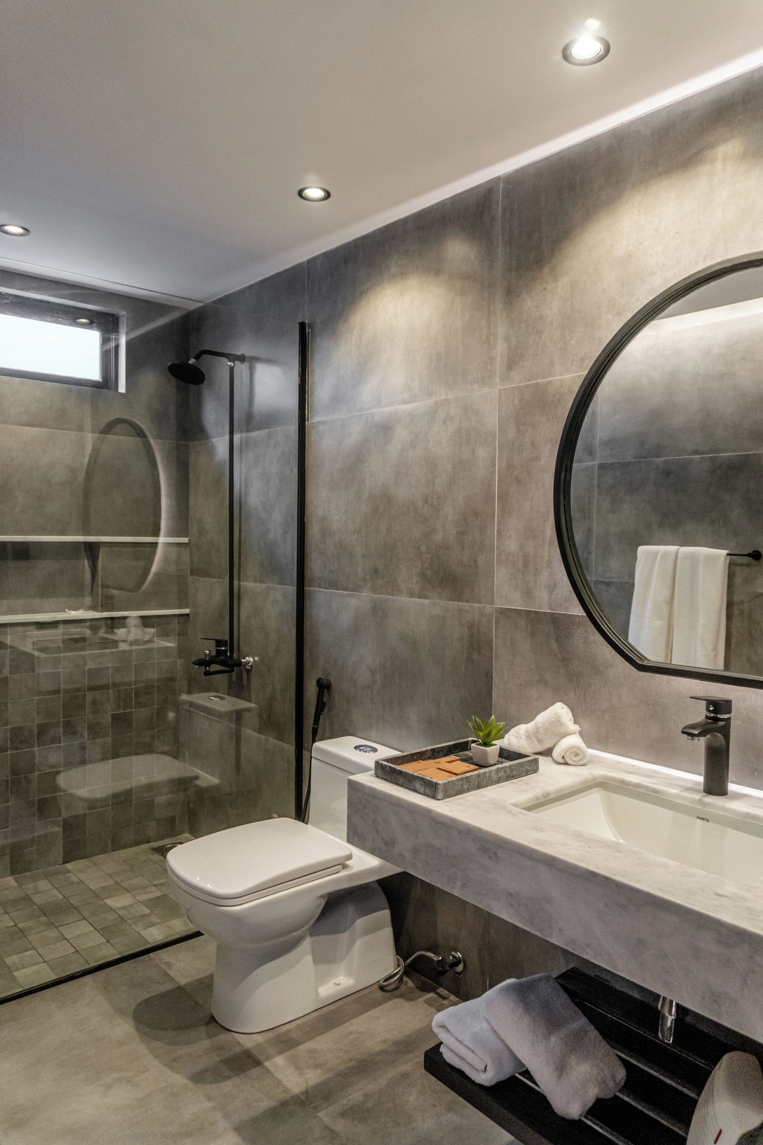 Un baño moderno con inodoro, lavamanos y ducha.
