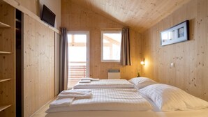 A wooden room with two beds, a TV, and a framed picture on the wall. - Appealing chalet with infrared sauna (Turracherhöhe)