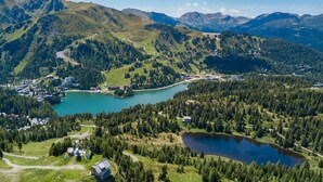 A mountainous landscape with a lake, a small town, and a road winding through the hills. - Chalet in Alps near Ski Slopes and Sauna (Turracherhöhe)