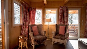 A cozy room with two wicker chairs, a small stool, and a lamp. - Chalet in Alps near Ski Slopes and Sauna (Turracherhöhe)