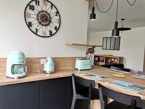 Eine Küche mit einer Uhr, einer Kaffeemaschine, einem Toaster und einer Holzauskład.