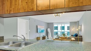 A modern kitchen with granite countertops, wooden cabinets, and a built-in dishwasher. - Beautiful 1BR Apartment with Amenities (Miami)