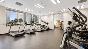 A gym with treadmills, a stationary bike, and a weight machine. - Beautiful 1BR Apartment with Amenities (Miami)