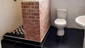 A bathroom with a shower, toilet, and sink. - Lotus House Harare (Harare)