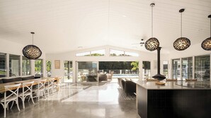 A spacious modern kitchen with a large island, white cabinetry, and pendant lighting.