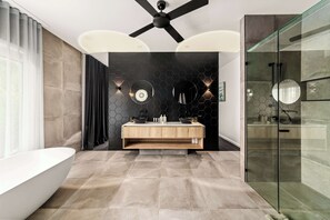 A modern bathroom with a freestanding bathtub, a vanity with a mirror, and a glass-enclosed shower area. - The Langville Estate in Kin Kin (Sunshine Coast Hinterland)